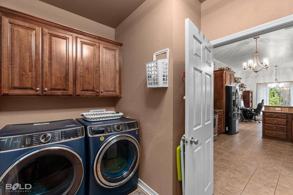 206 Silver Fox Circle, Haughton, LA 71037 Laundry room featuring custom wood cabinetry, tiled flooring, and a six-panel interior door