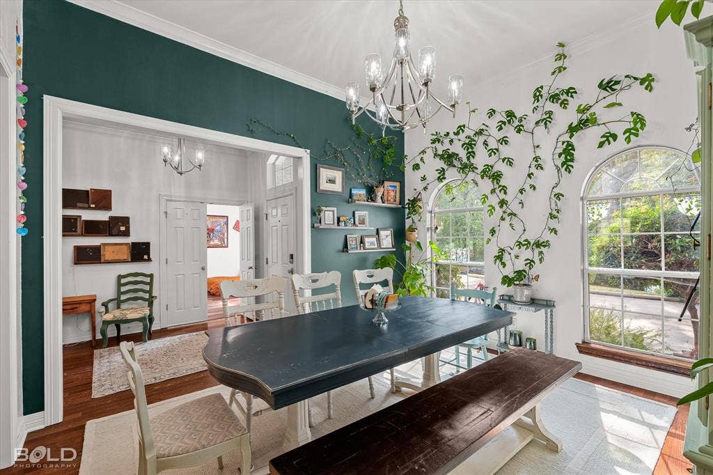 206 Silver Fox Circle, Haughton, LA 71037 Dining room featuring wood-finish flooring, crown molding, a decorative multi-arm chandelier, and two arched windows