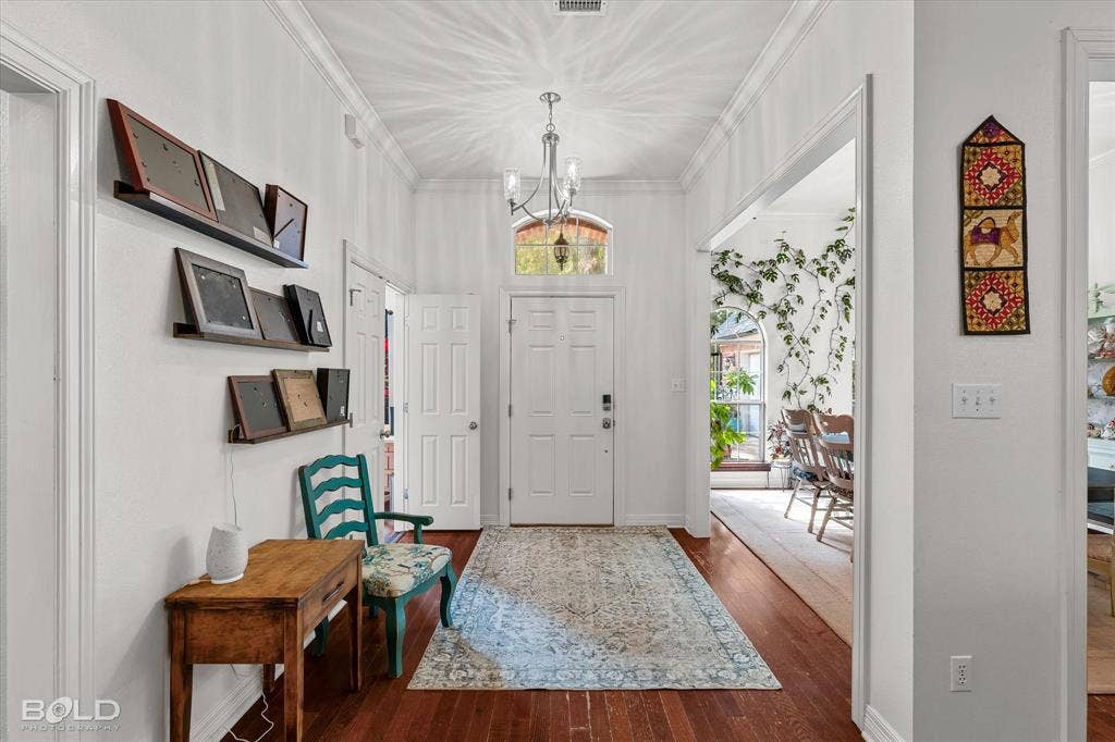 206 Silver Fox Circle, Haughton, LA 71037 Entryway featuring hardwood flooring, crown molding, a multi-light chandelier, and an arched transom window above the front door