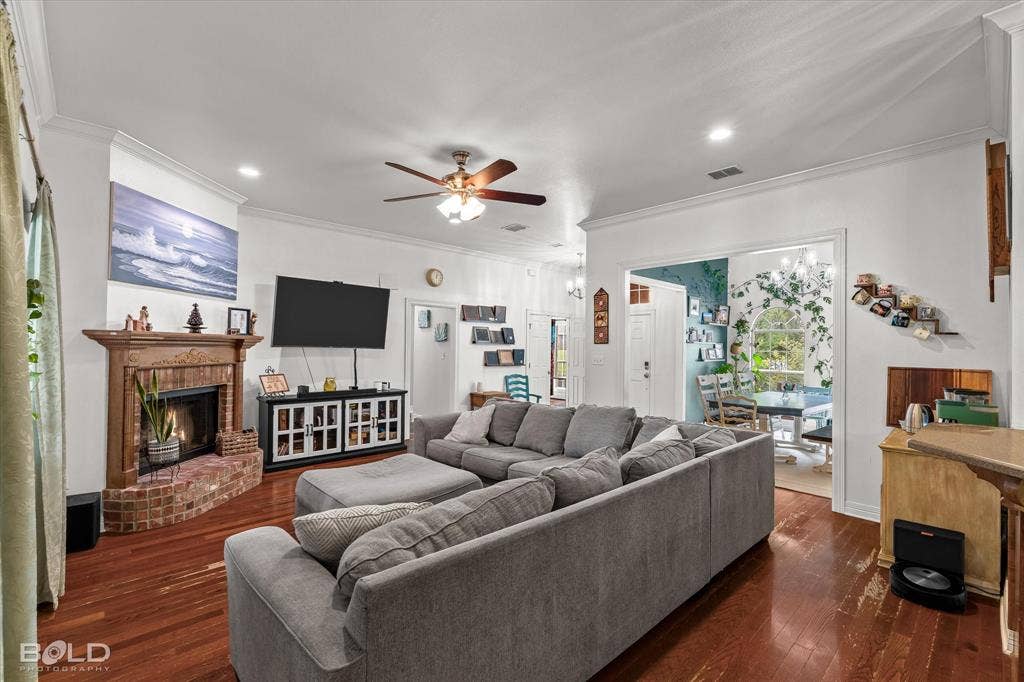 206 Silver Fox Circle, Haughton, LA 71037 Living room featuring wood-finish flooring, a corner brick fireplace with a carved wooden mantel, recessed lighting, and a ceiling fan