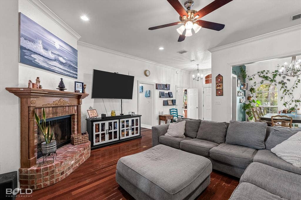 206 Silver Fox Circle, Haughton, LA 71037 Living area featuring hardwood flooring, a ceiling fan with integrated lighting, and a brick fireplace with a decorative wood mantel