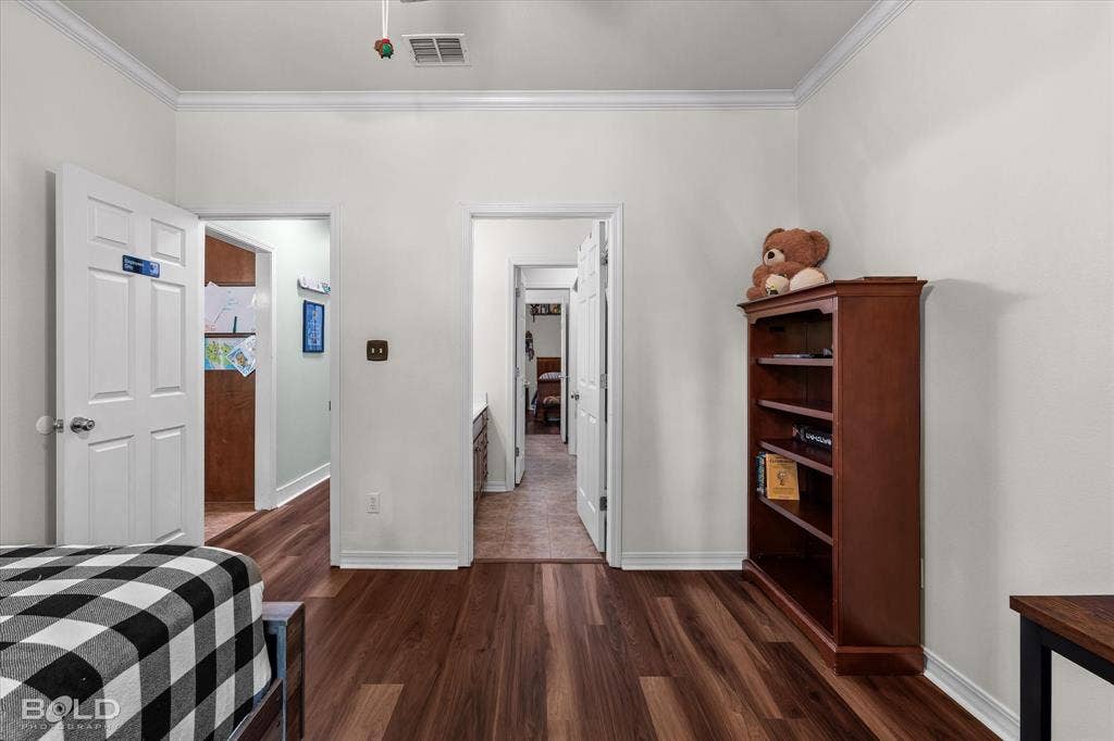 206 Silver Fox Circle, Haughton, LA 71037 Room featuring wood-finish flooring, crown molding, and multiple four-panel interior doors