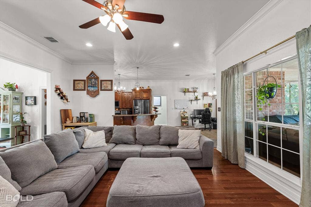 206 Silver Fox Circle, Haughton, LA 71037 Open-concept living space featuring wood-finish flooring, recessed lighting, crown molding, a ceiling fan, and large windows with grid detailing