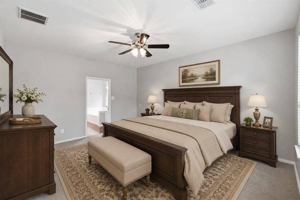 Carpeted flooring, vaulted ceiling, ceiling fan with integrated lighting, window with blinds, and an open doorway