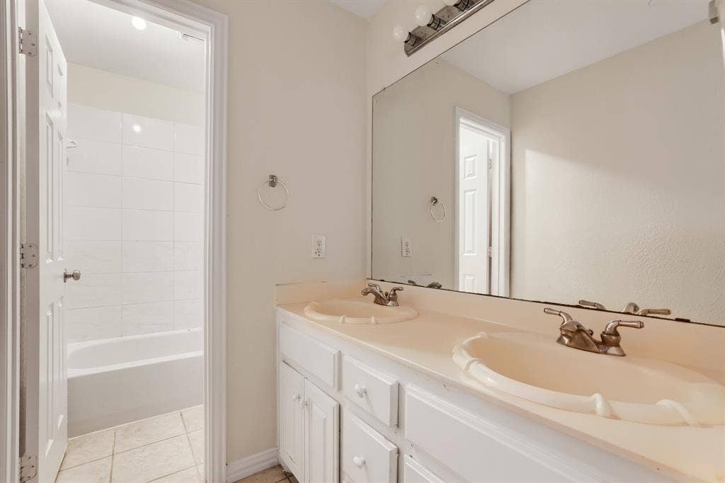 8115 Dogwood Lane, Irving, TX 75063 Dual vanity with integrated sinks, brushed nickel fixtures, and white cabinetry