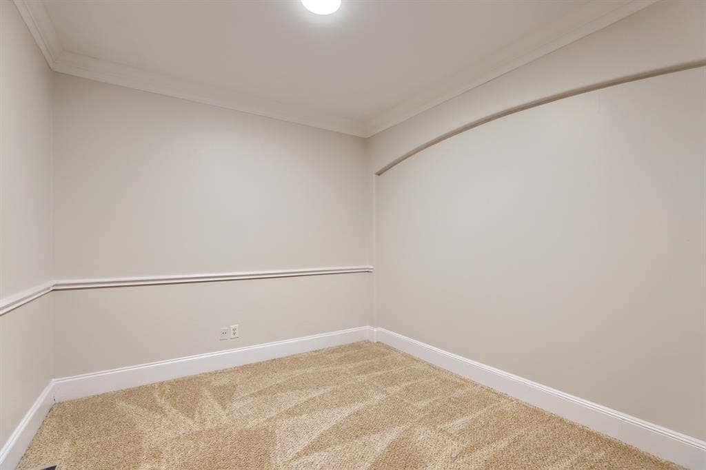 8115 Dogwood Lane, Irving, TX 75063 Neutral wall paint, crown molding, chair rail, and recessed wall arch