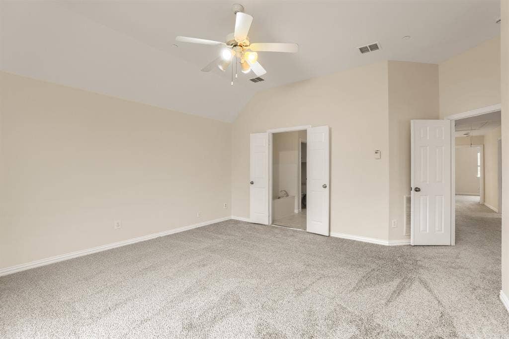 8115 Dogwood Lane, Irving, TX 75063 Vaulted ceiling with an attached ceiling fan, neutral carpet flooring, and white interior doors
