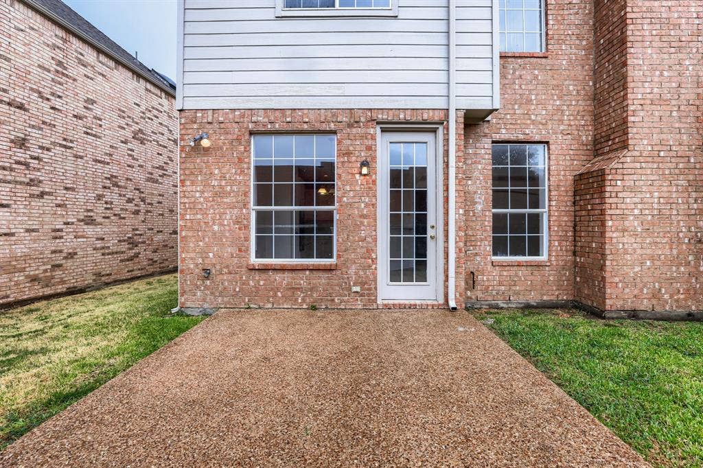 8115 Dogwood Lane, Irving, TX 75063 Textured aggregate patio with brick exterior and white siding