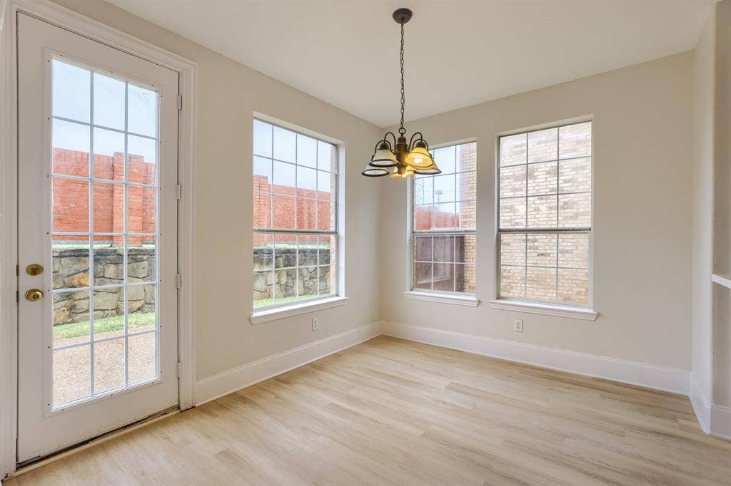 8115 Dogwood Lane, Irving, TX 75063 Light-toned wood-finish flooring, multiple grid-pane windows, and a glass-pane door