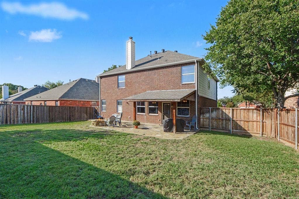 6509 Cartier Court, McKinney, TX 75072 Expansive backyard featuring a brick exterior, covered patio, stone patio, and wood privacy fencing