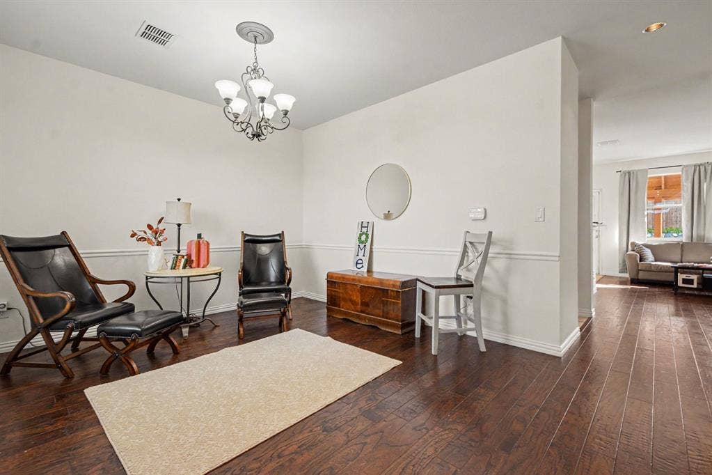 6509 Cartier Court, McKinney, TX 75072 Dark wood-finish flooring, white walls with wainscoting, and an ornate chandelier