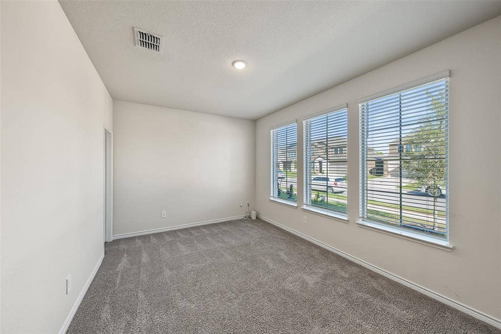 Carpeted room featuring three windows with blinds, recessed ceiling lighting, and a white ceiling