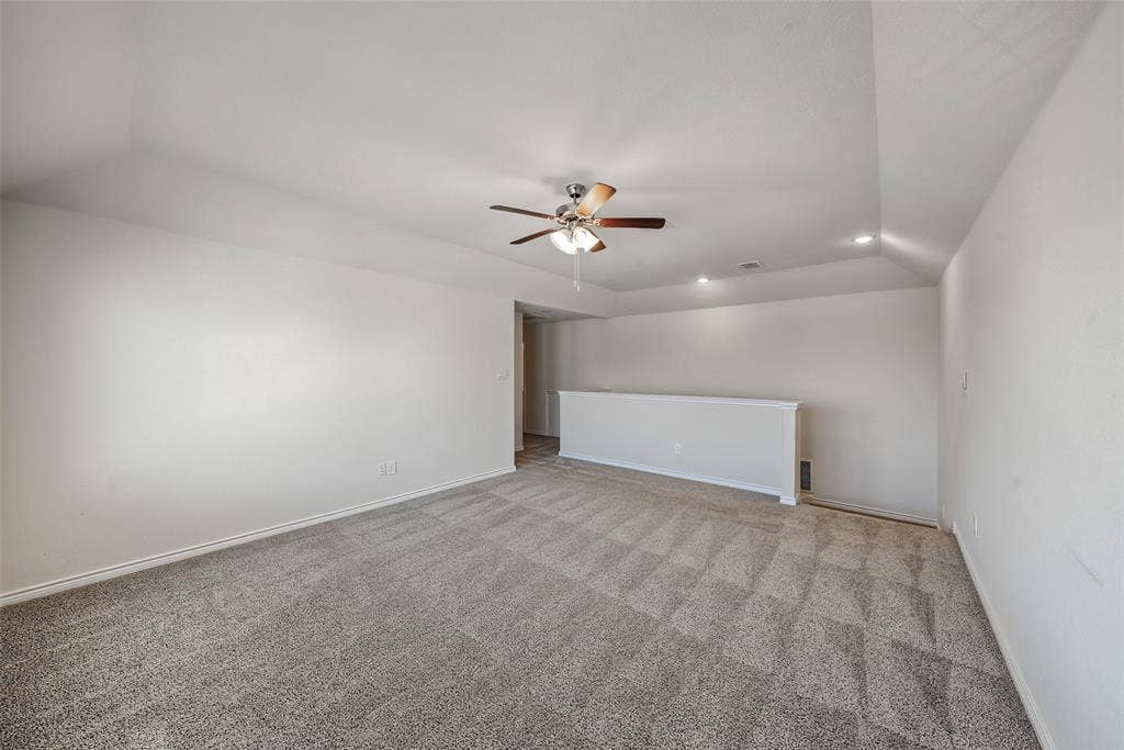 Carpeting throughout, vaulted ceiling, recessed lighting, and a ceiling fan with light