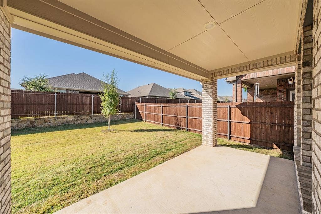 Covered back patio with large backyard