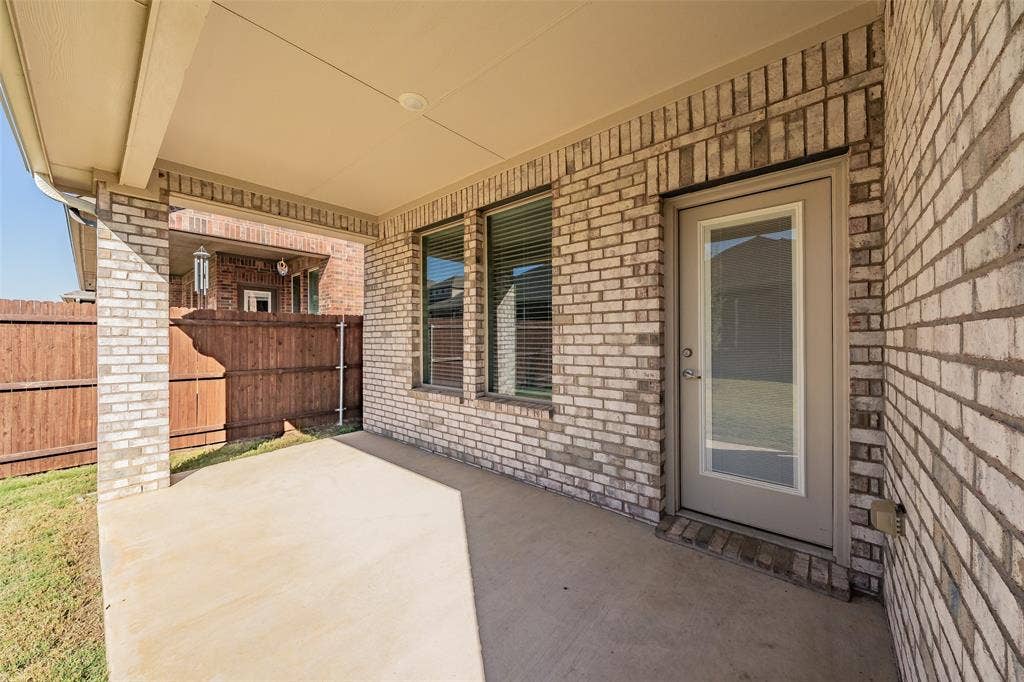 Covered back patio featuring a concrete slab and brick columns