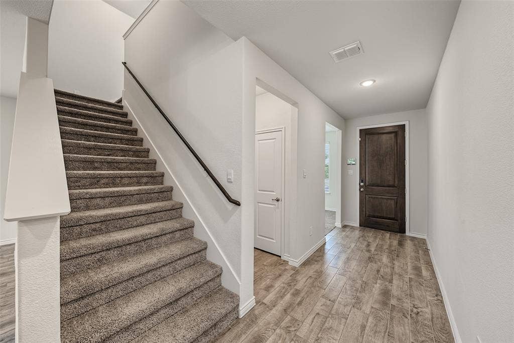 Entryway featuring porcelain tile flooring, a dark wood-paneled door, and recessed lighting