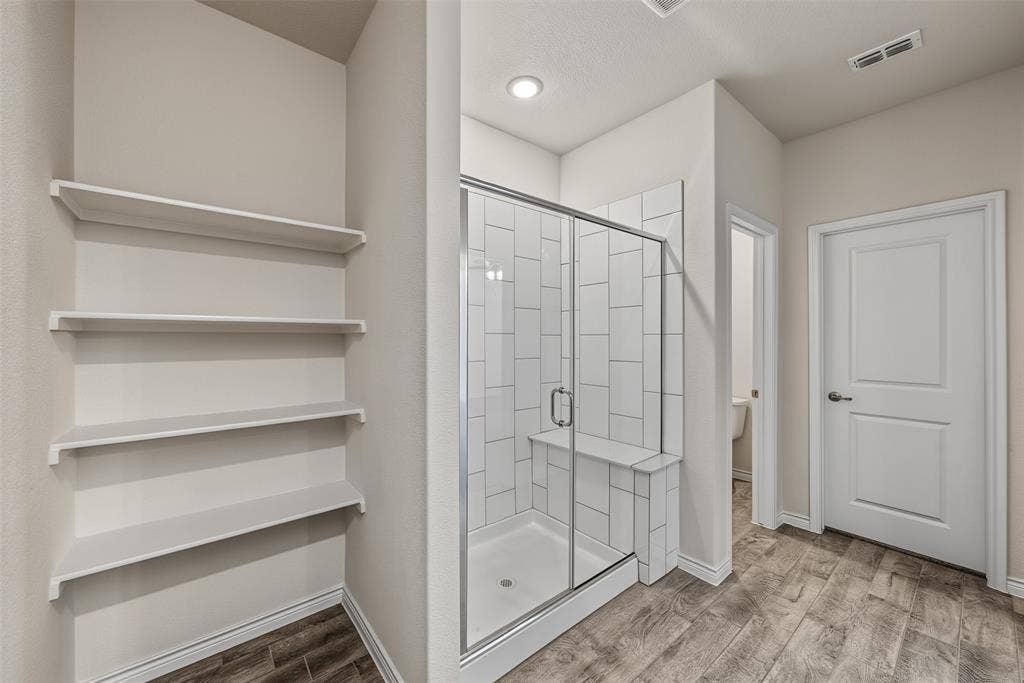Spacious walk-in shower with vertical tile surround and built-in bench