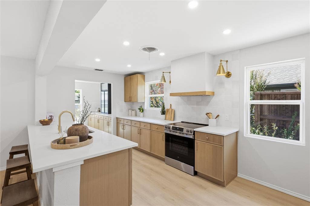 1521 Glenwick Drive, Plano, TX 75075 Kitchen featuring wood-finish cabinetry, quartz countertops, a matching hood vent, stainless steel range, and recessed lighting