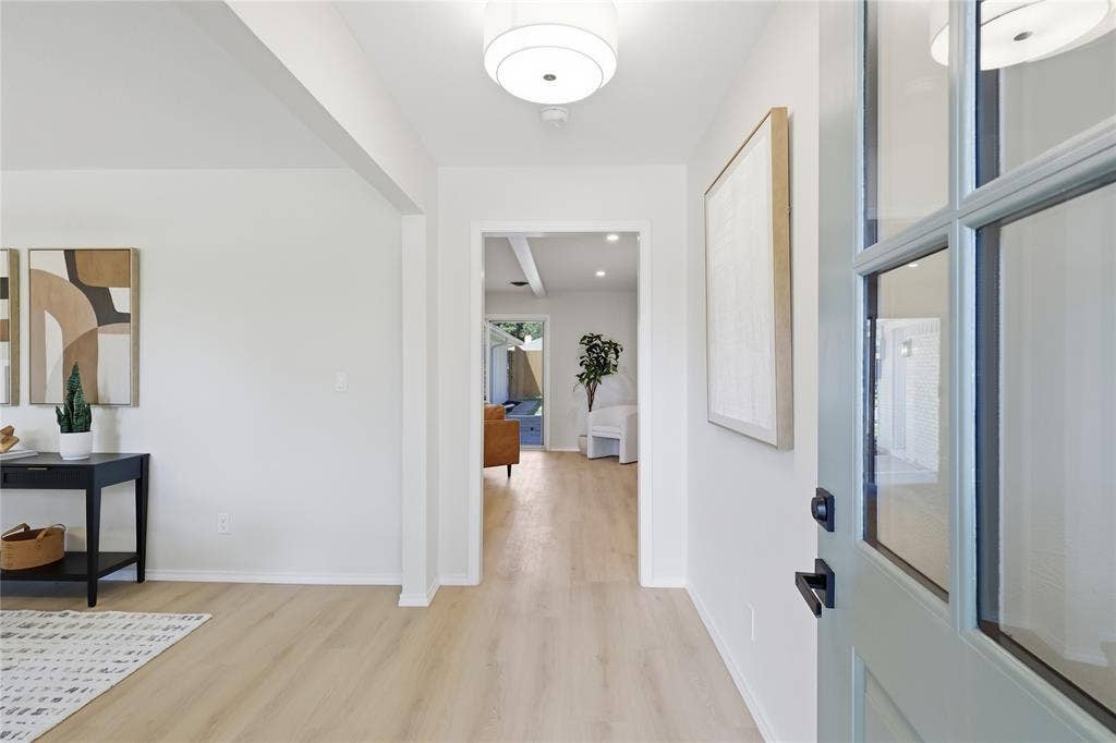 1521 Glenwick Drive, Plano, TX 75075 Entryway featuring light-toned wood-finish flooring, a multi-pane glass-inset door, and a modern drum pendant light fixture