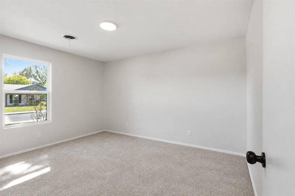 1521 Glenwick Drive, Plano, TX 75075 Neutral-toned interior space featuring wall-to-wall carpeting, a flush-mount ceiling light fixture, and a single-pane window with exterior exposure