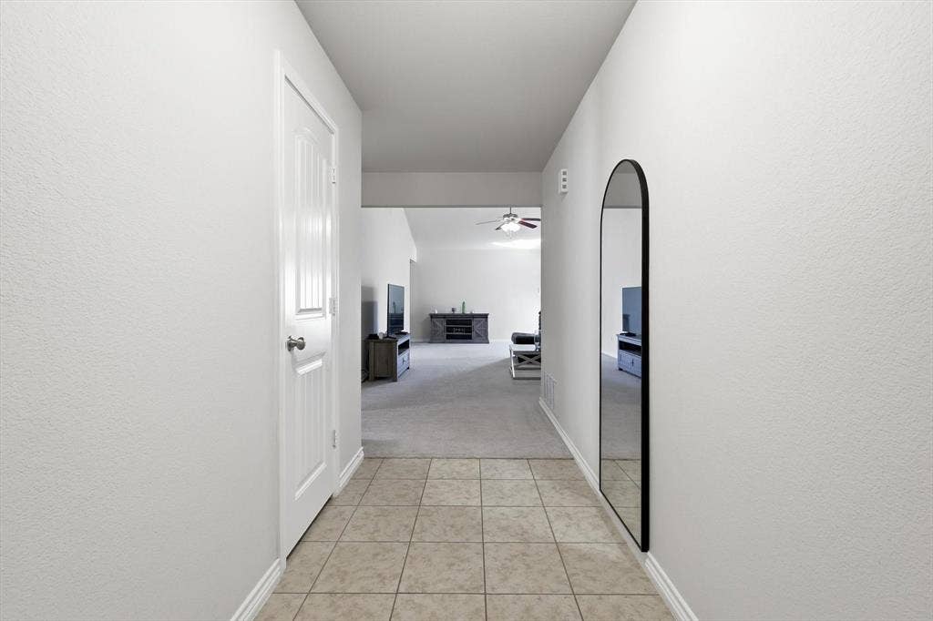 Tiled entryway flooring extending into a carpeted interior space