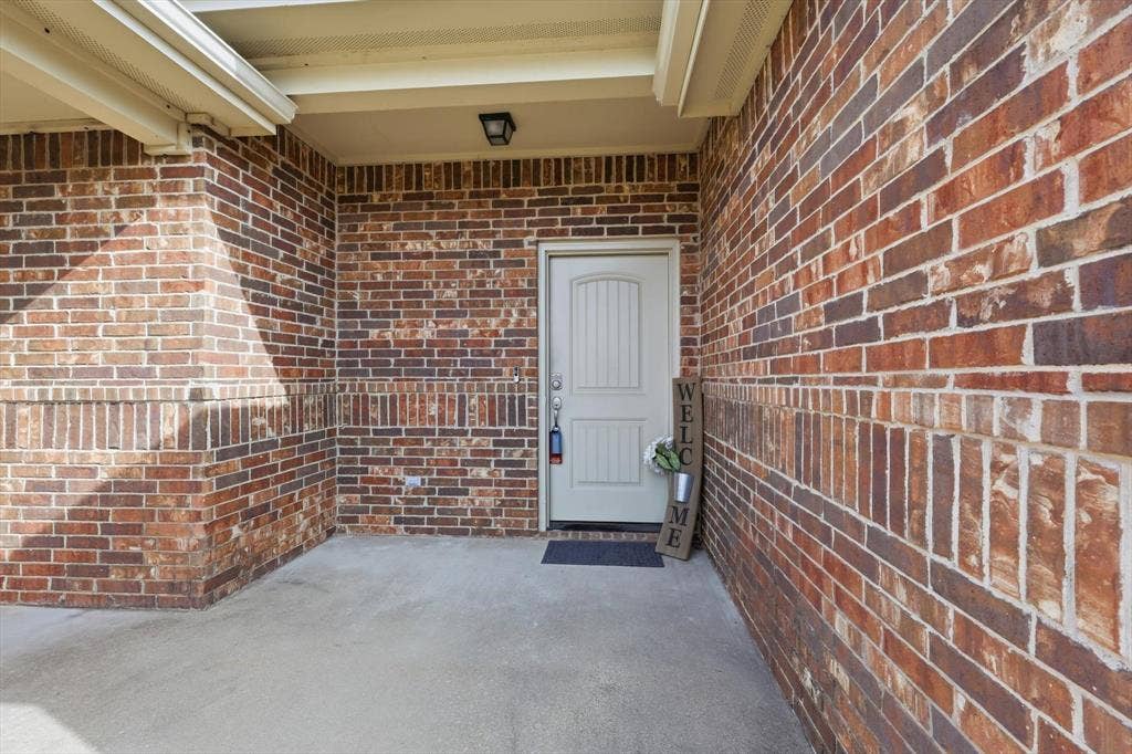 Brick exterior with decorative band, covered entryway, and a panel-style front door