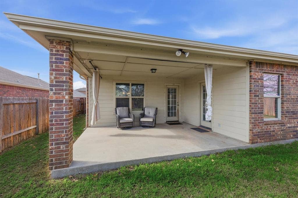 Covered concrete patio featuring brick columns, recessed lighting, and dual exterior doors