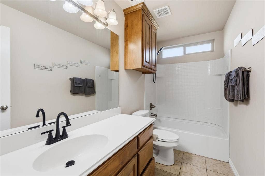 Single vanity with an integrated sink, matte black faucet, and wood-finish cabinetry