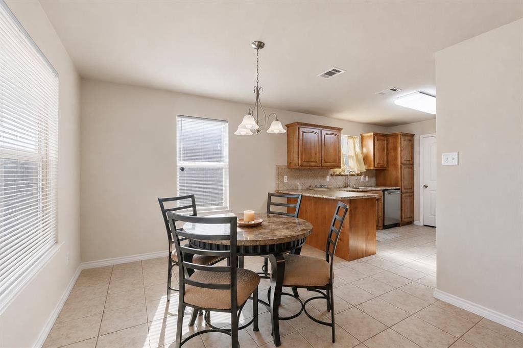 Open-concept dining area with tile flooring and a multi-light pendant fixture