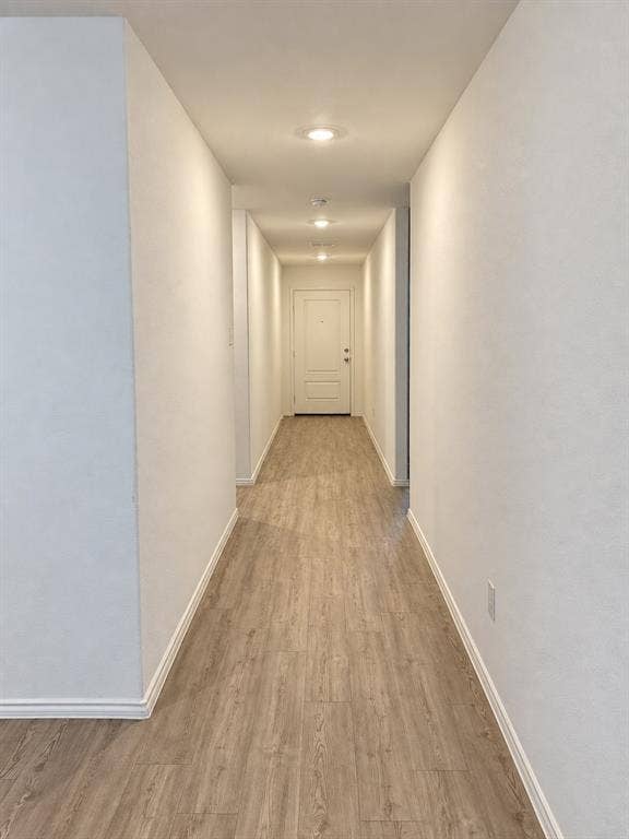 Bright, welcoming entry hallway featuring luxury vinyl plank flooring, recessed lighting, and neutral finishes that create a clean, cohesive look