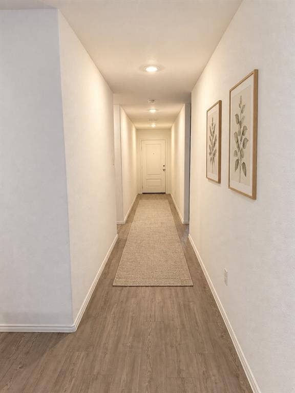 *Virtually Staged* Bright, welcoming entry hallway featuring luxury vinyl plank flooring, recessed lighting, and neutral finishes that create a clean, cohesive look.
