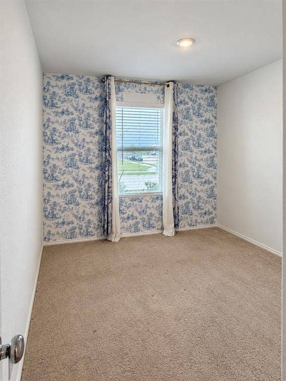 Versatile secondary bedroom featuring neutral carpeting, recessed lighting, a large window for natural light, and an accent wall that adds character to the space.