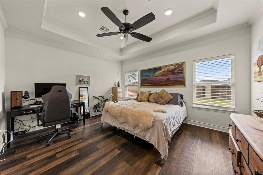 Tray ceiling with recessed lighting and a ceiling fan, wood-finish flooring, and multiple windows
