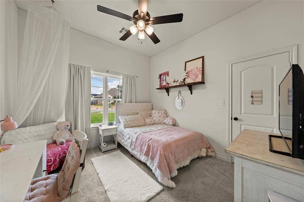 White painted walls, arched interior door, ceiling fan with light kit, and a double-pane window