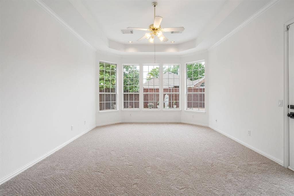 3307 Meadow Wood Drive, Richardson, TX 75082 Recessed bay window, neutral carpeting, tray ceiling, ceiling fan, and crown molding