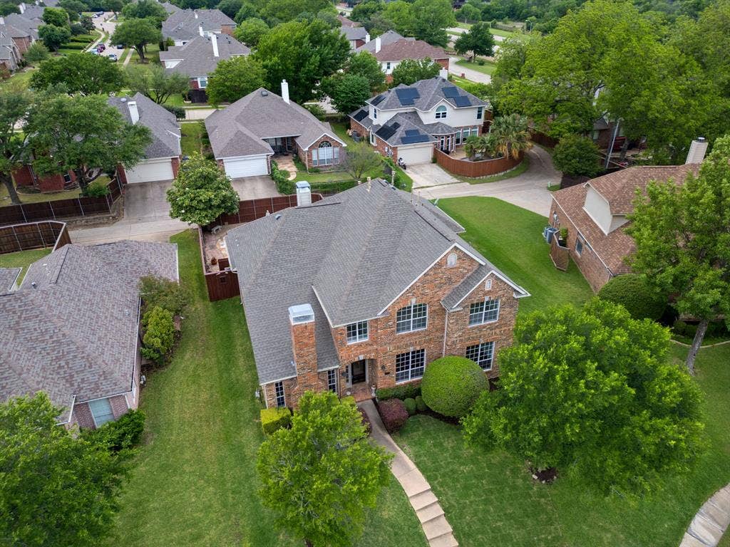 3307 Meadow Wood Drive, Richardson, TX 75082 Brick exterior with multiple windows, a gabled roof, and a mature tree