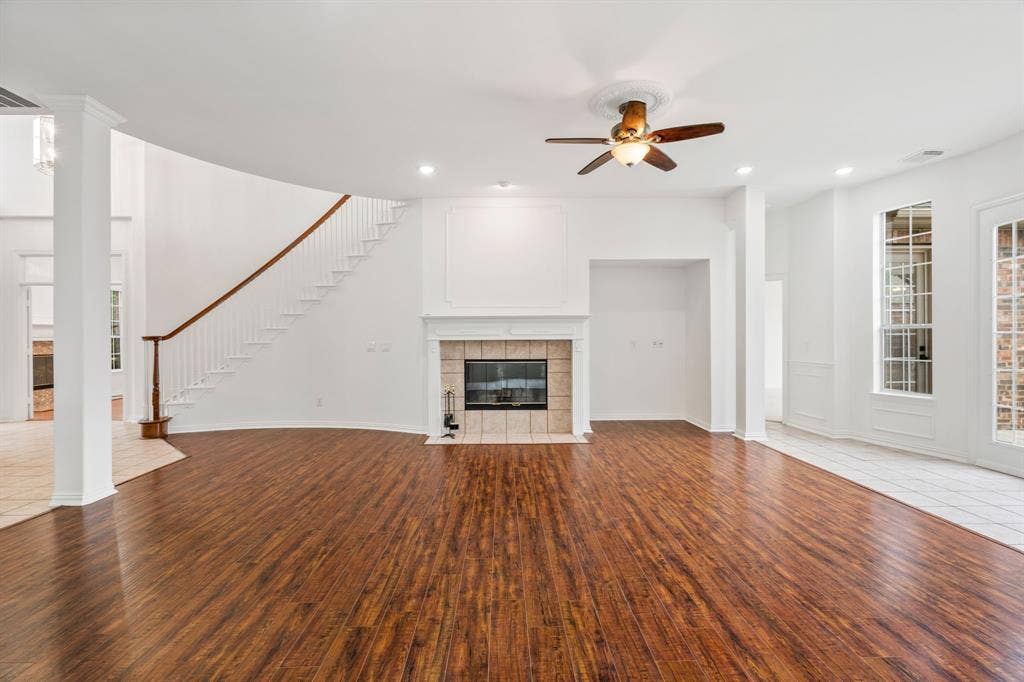 3307 Meadow Wood Drive, Richardson, TX 75082 Spacious living area featuring wood-finish flooring, a fireplace with a tile surround, and a ceiling fan