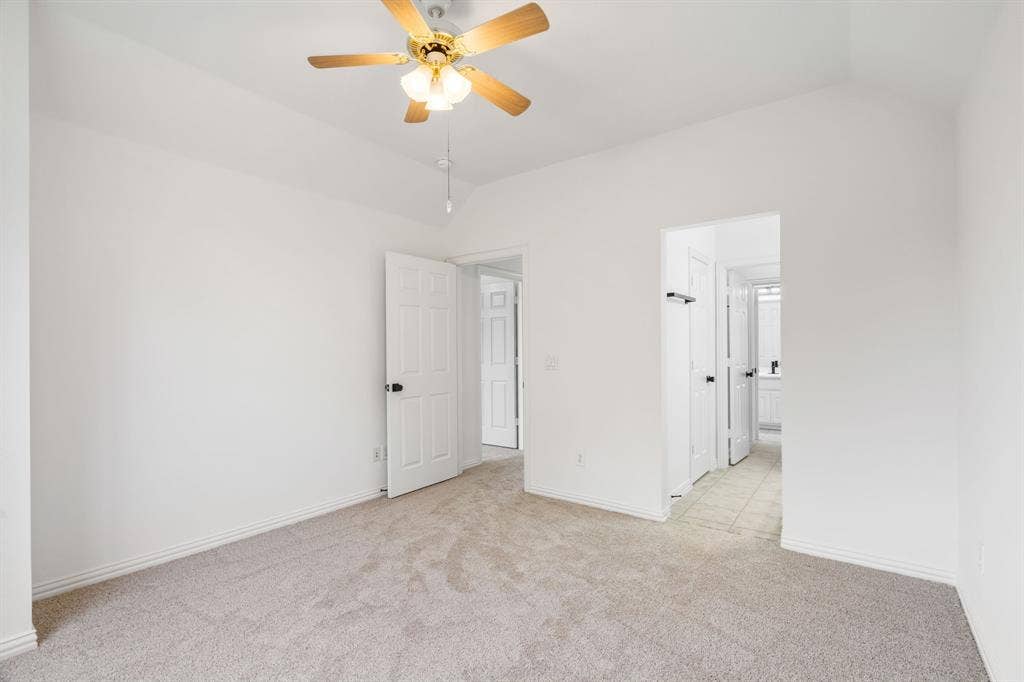 3307 Meadow Wood Drive, Richardson, TX 75082 Vaulted ceiling with an attached ceiling fan, neutral wall finishes, carpeted flooring, and a white paneled door