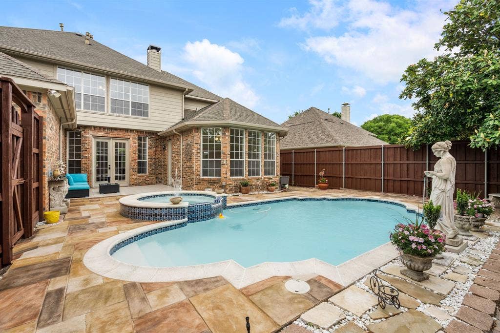 3307 Meadow Wood Drive, Richardson, TX 75082 Expansive backyard featuring a custom pool with a built-in spa, brick and siding exterior, and a large patio area