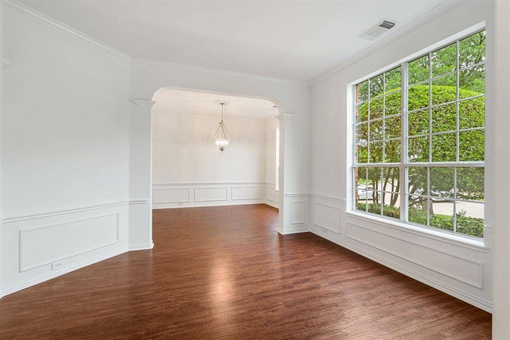 3307 Meadow Wood Drive, Richardson, TX 75082 Hardwood flooring, arched doorway, wainscoting, crown molding, and large multi-pane window