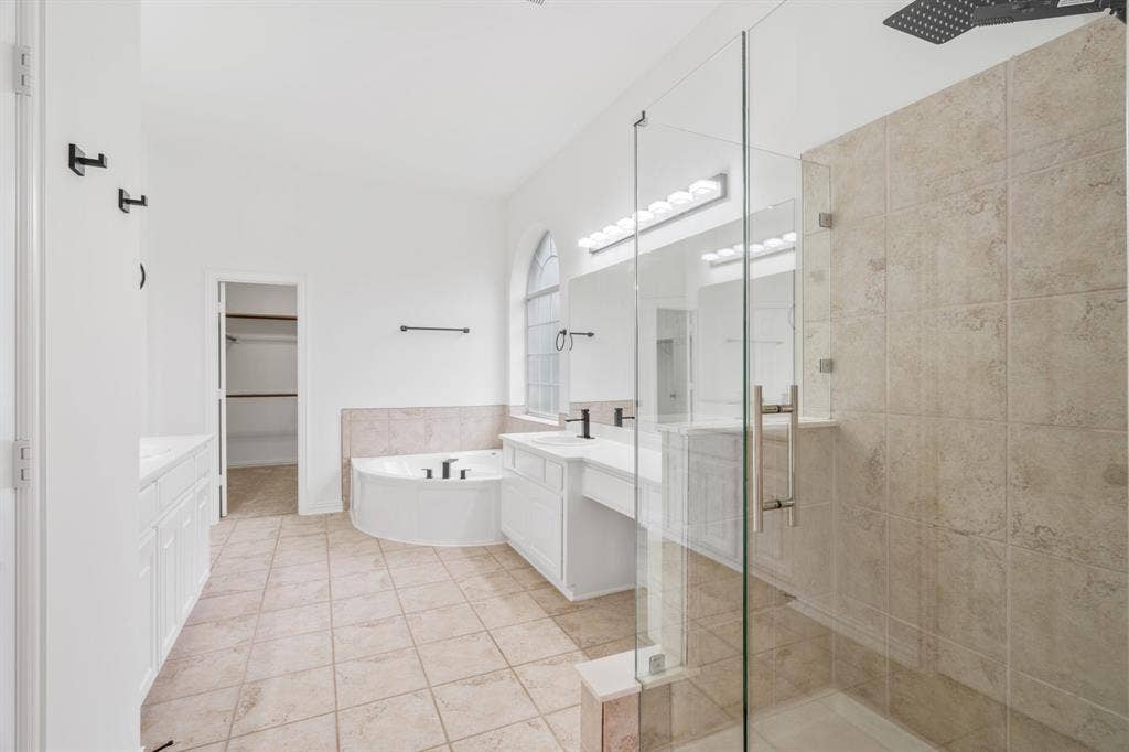 3307 Meadow Wood Drive, Richardson, TX 75082 Spacious bathroom featuring a built-in soaking tub, glass-enclosed shower, dual vanity with undermount sinks, and tile flooring
