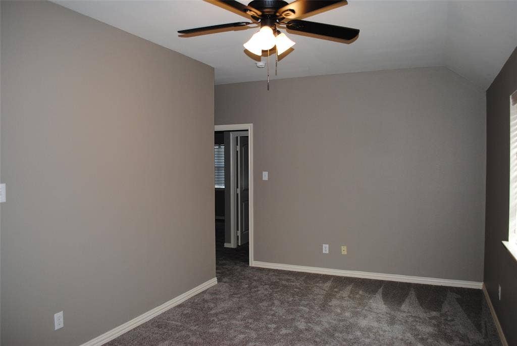 5108 Blackwood Drive, McKinney, TX 75071 Vaulted ceiling with a ceiling fan, neutral wall tones, and carpeted flooring