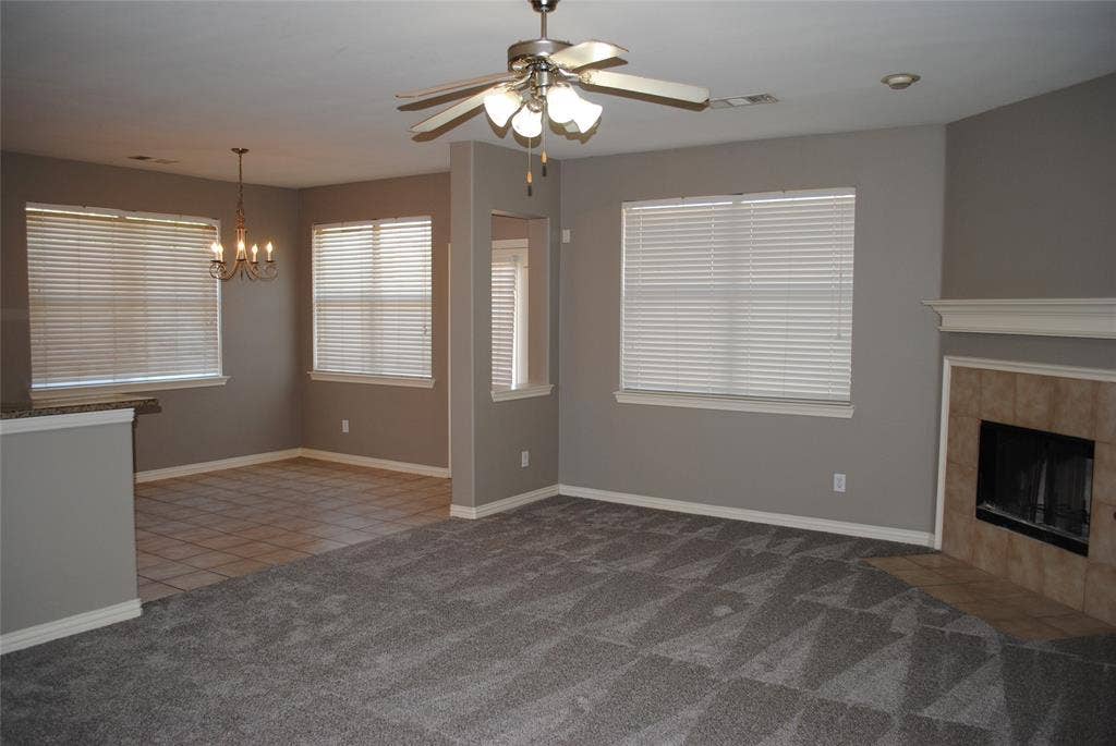 5108 Blackwood Drive, McKinney, TX 75071 Open concept living area with a fireplace featuring a tile surround and mantel