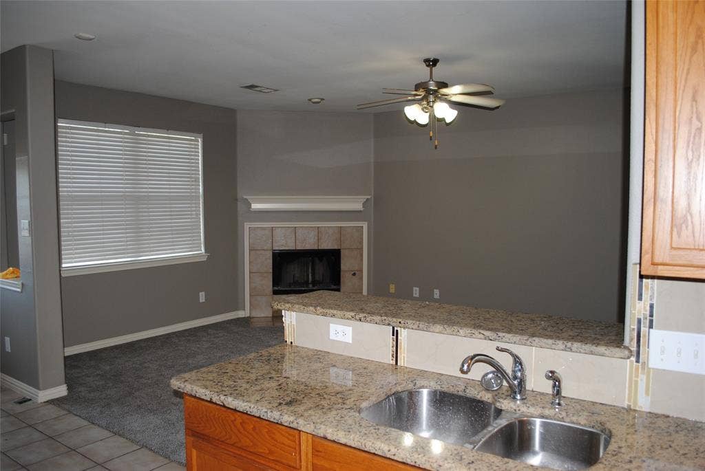 5108 Blackwood Drive, McKinney, TX 75071 Kitchen with granite countertops, double basin stainless steel sink, and wood cabinetry
