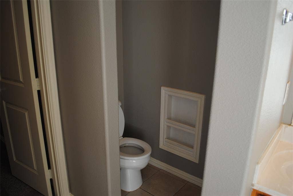 5108 Blackwood Drive, McKinney, TX 75071 Recessed wall shelving, tiled flooring, and a white toilet