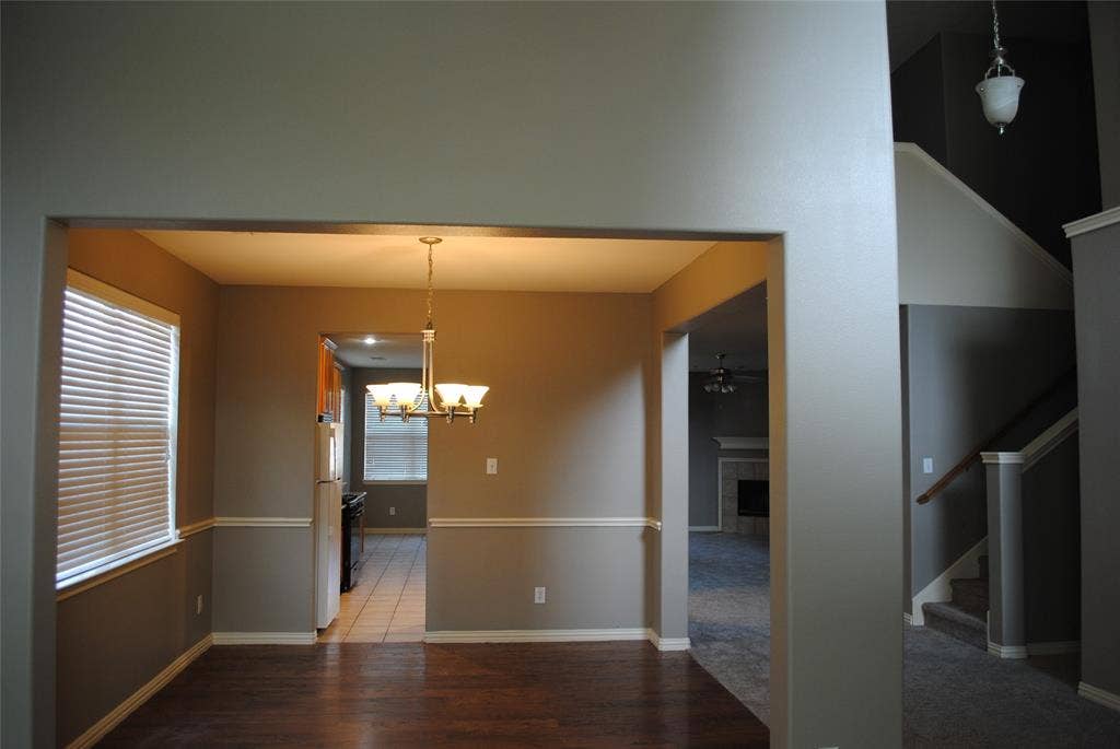 5108 Blackwood Drive, McKinney, TX 75071 Wood-finish flooring, chair rail molding, and a chandelier illuminate the space