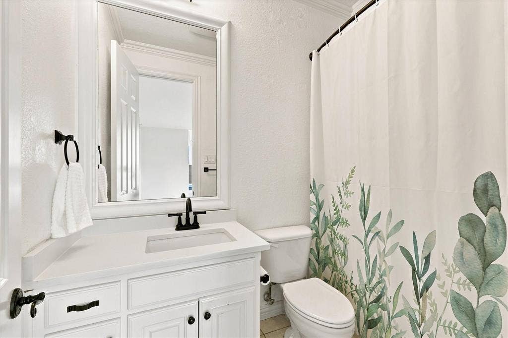 White vanity with integrated sink and matte black faucet