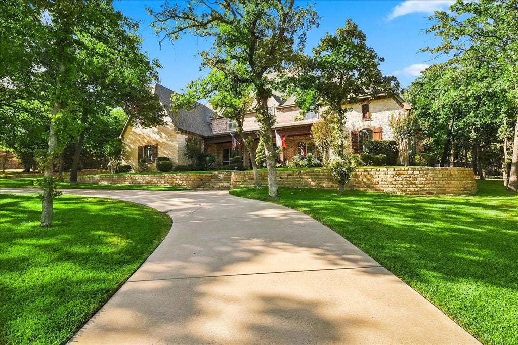 Stone exterior with an arched entryway, gabled roofline, and wood shutters