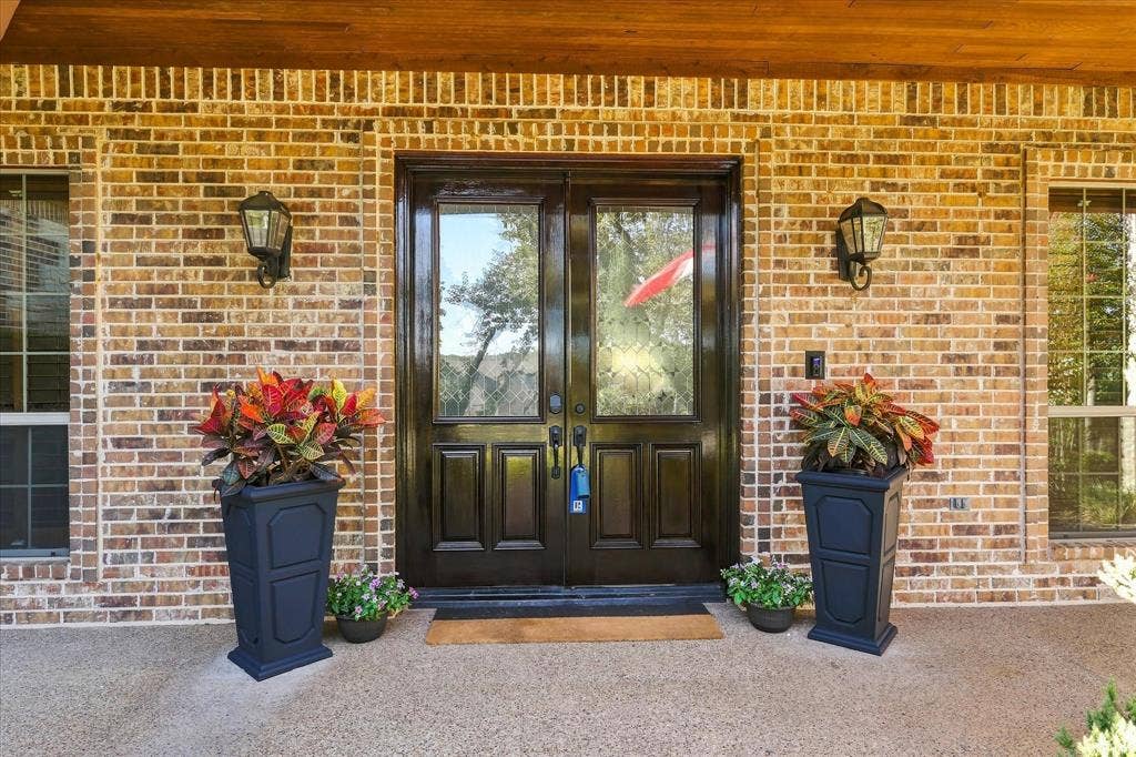 Brick exterior with a wooden beam accent and double entry doors