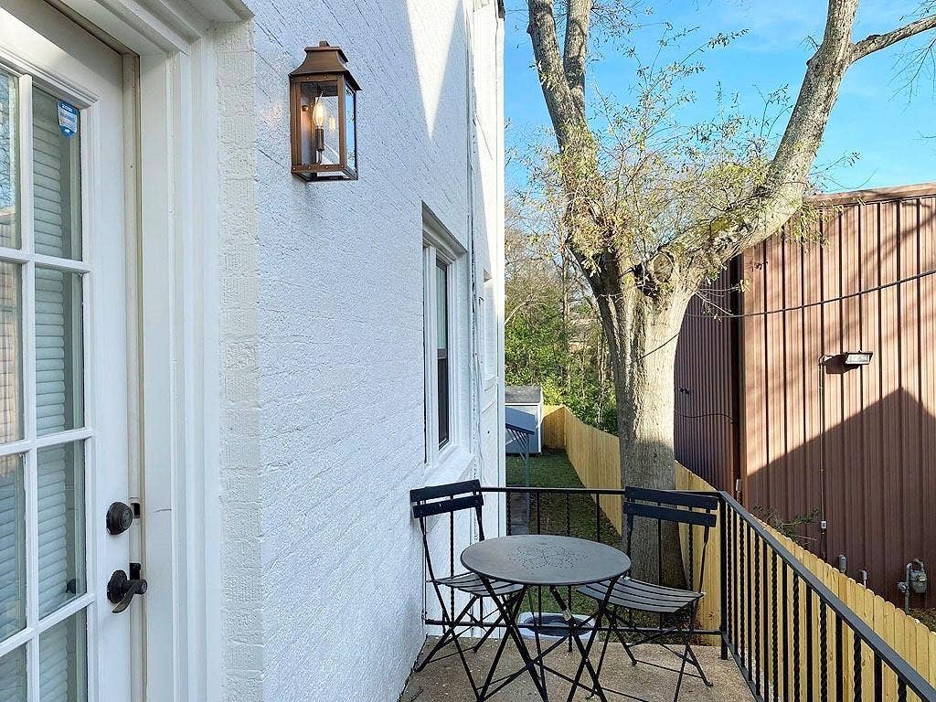 434 S Vine Avenue, Tyler, TX 75702 Private balcony with iron railing, exterior wall lantern, and a wood privacy fence